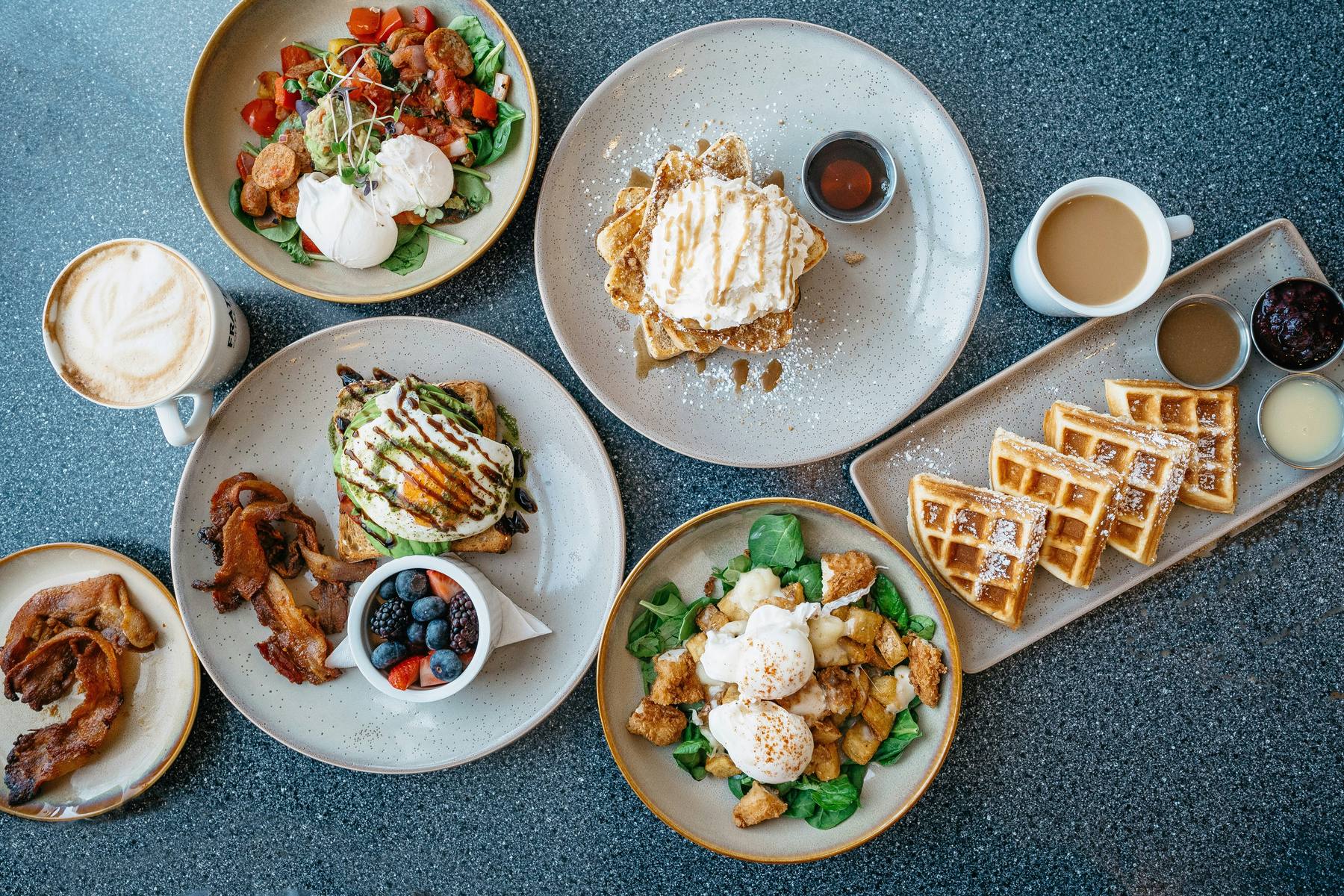 Frühstückstisch im Kantofino: Eier, Waffeln, Avocado-Toast, Speck und Kaffee